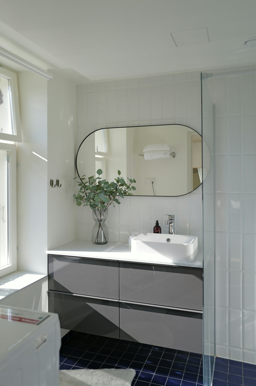 Salle de bain lumineuse avec un grand miroir
